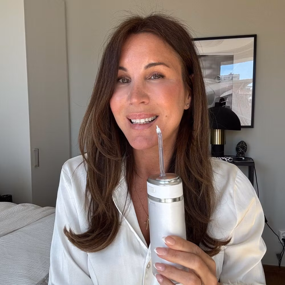 En kvinde holder Water Flosser Pro derhjemme